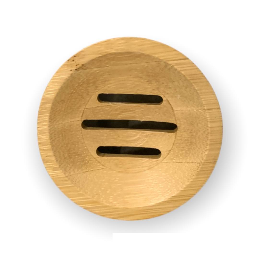 The Cammellatte Soap Saver, a round wooden dish with three drainage slits, prolongs soaps lifespan. Its natural grain complements a bamboo tray style, set against a white background.