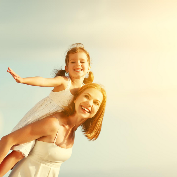 Woman Piggy Backing Daughter in the sun
