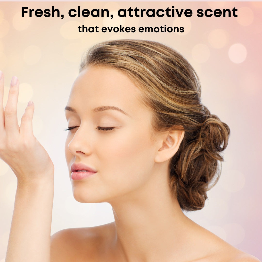 With closed eyes, a person inhales the fragrance from their wrist, showcasing smooth skin. Above, it reads: Delicious Body Butter by Cammellatte: a fresh, clean scent that evokes emotions. The background features softly blurred pastel colors.