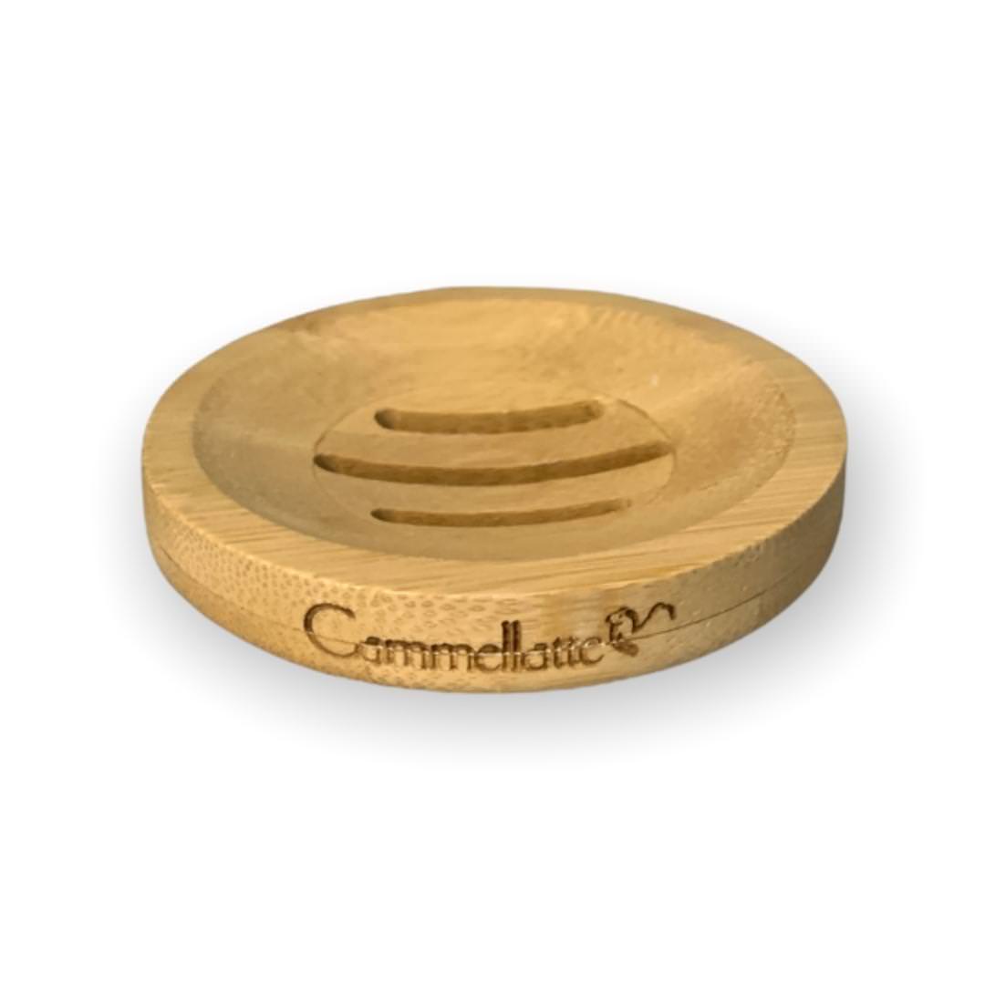 The Soap Saver by Cammellatte is a round, wooden dish with carved grooves that elegantly holds your soap, extending its lifespan. Engraved with Cammellatte, it rests gracefully against a plain white background.